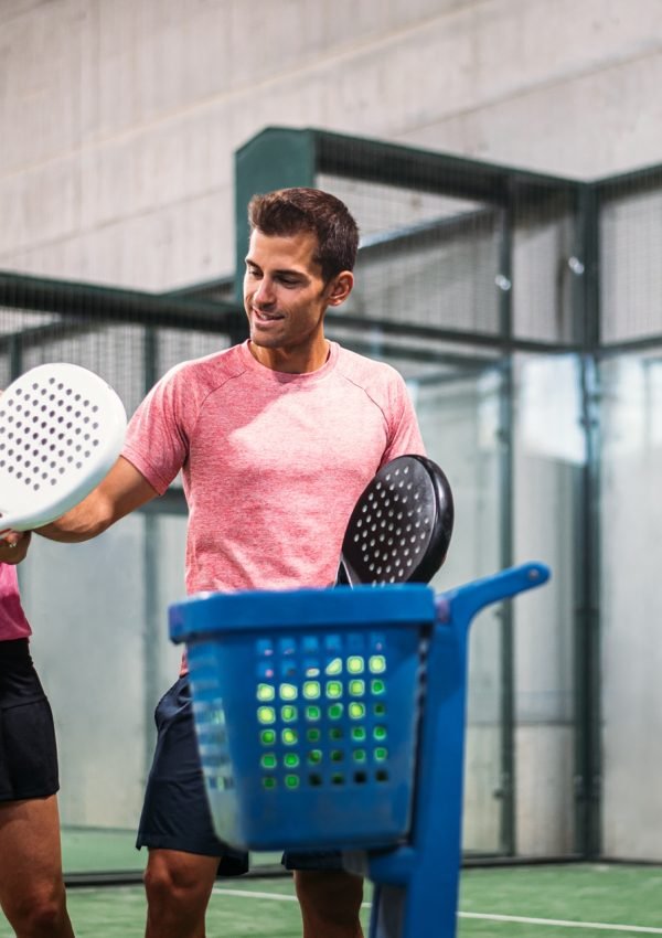 Monitor teaching padel class to woman